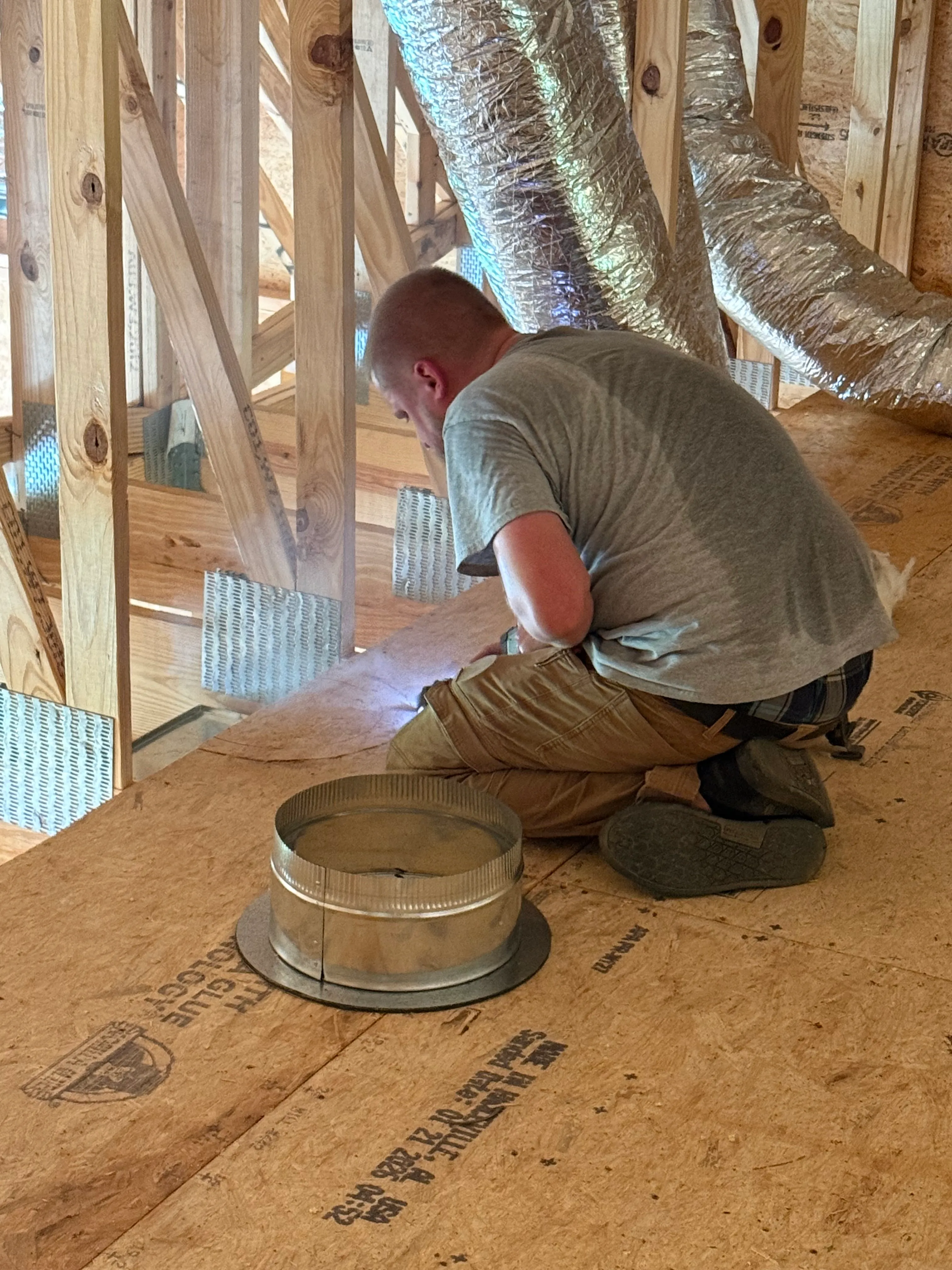 East Tennessee Air Company technician fitting a duct register boot in a new construction home in Knoxville, TN
