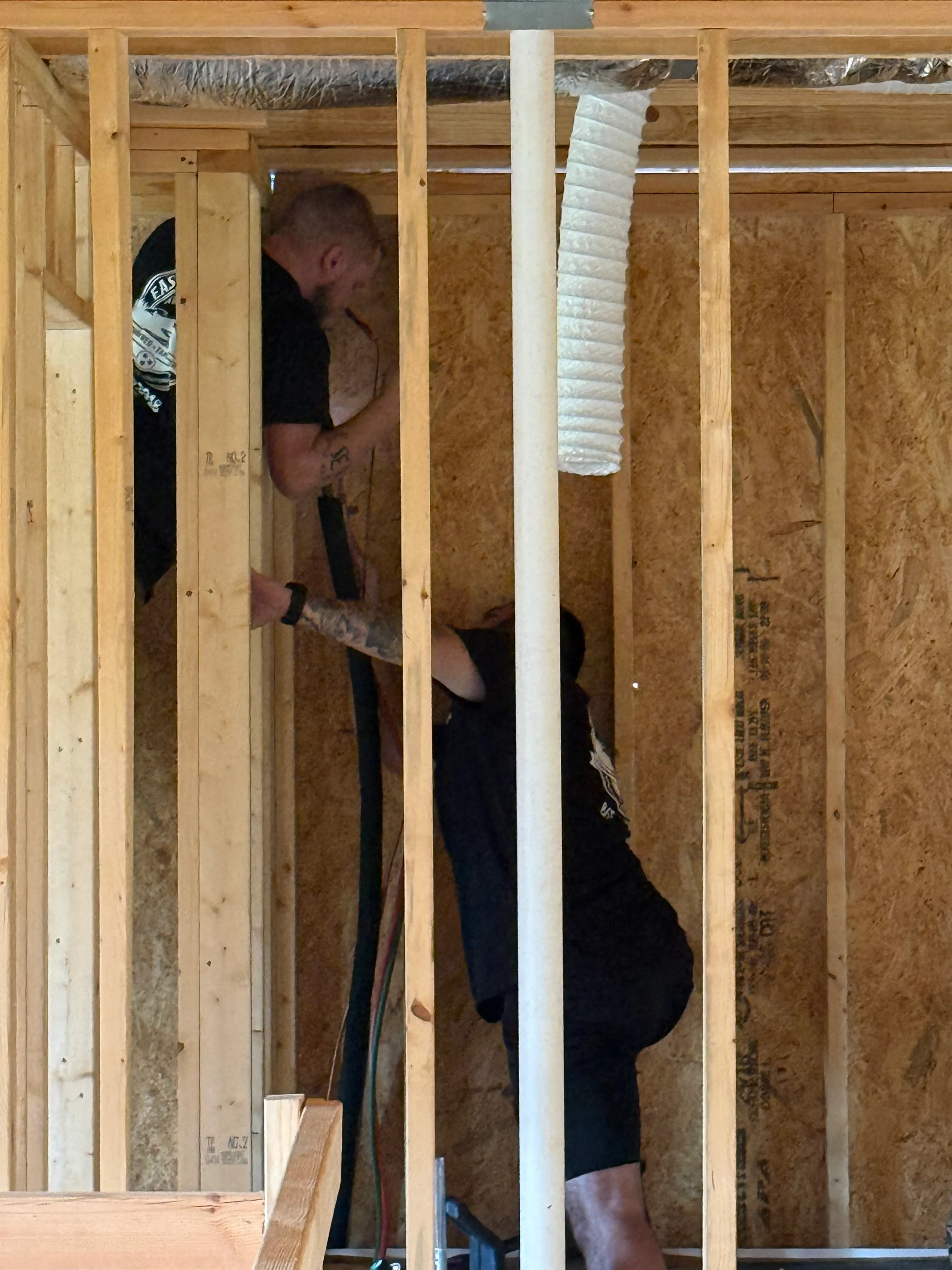 East Tennessee Air Company technicians running flexible ductwork through floor joists in a new construction home in Knoxville, TN