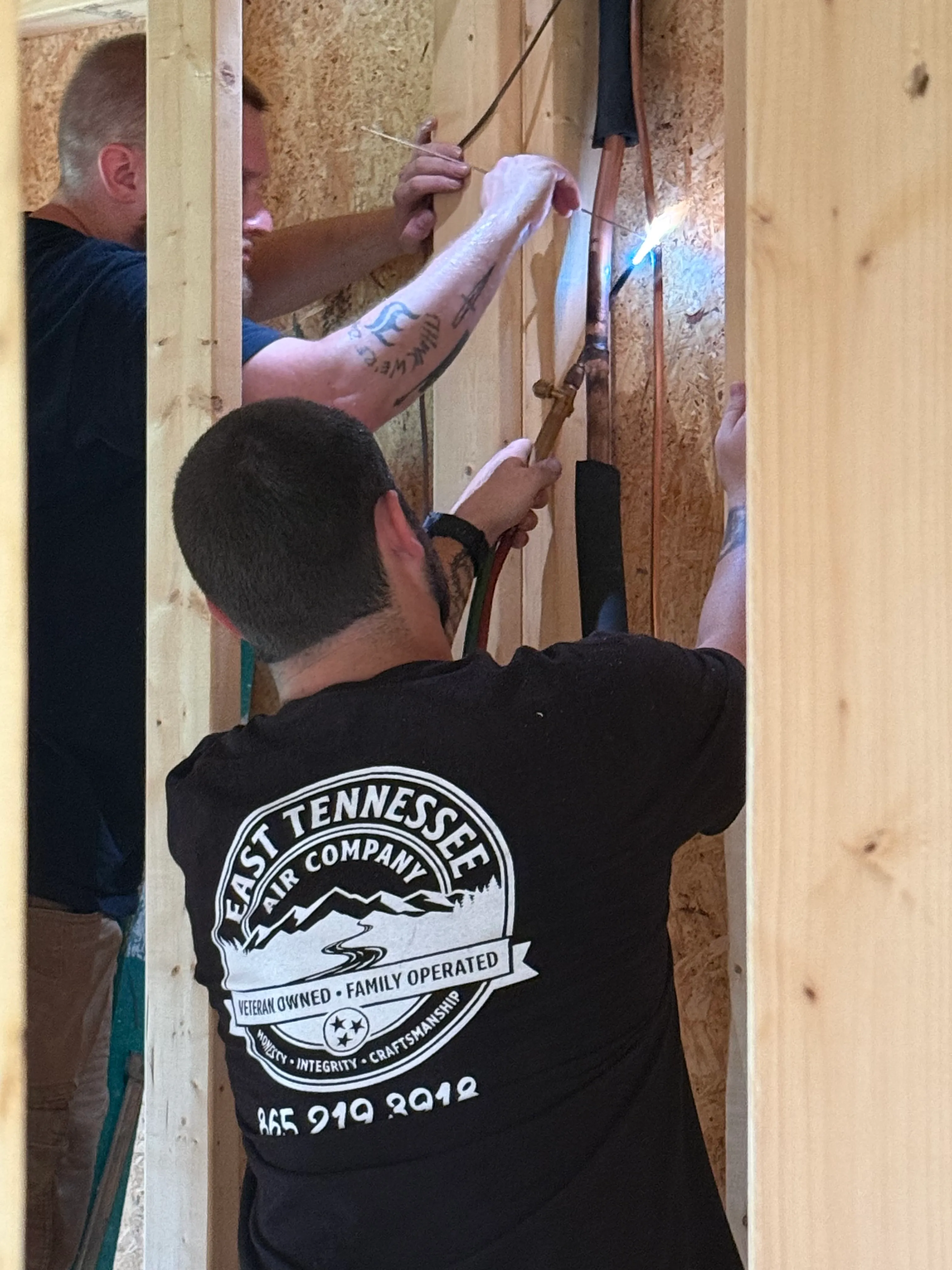 East Tennessee Air Company technician brazing copper refrigerant lines on a new construction HVAC install in Knoxville, TN